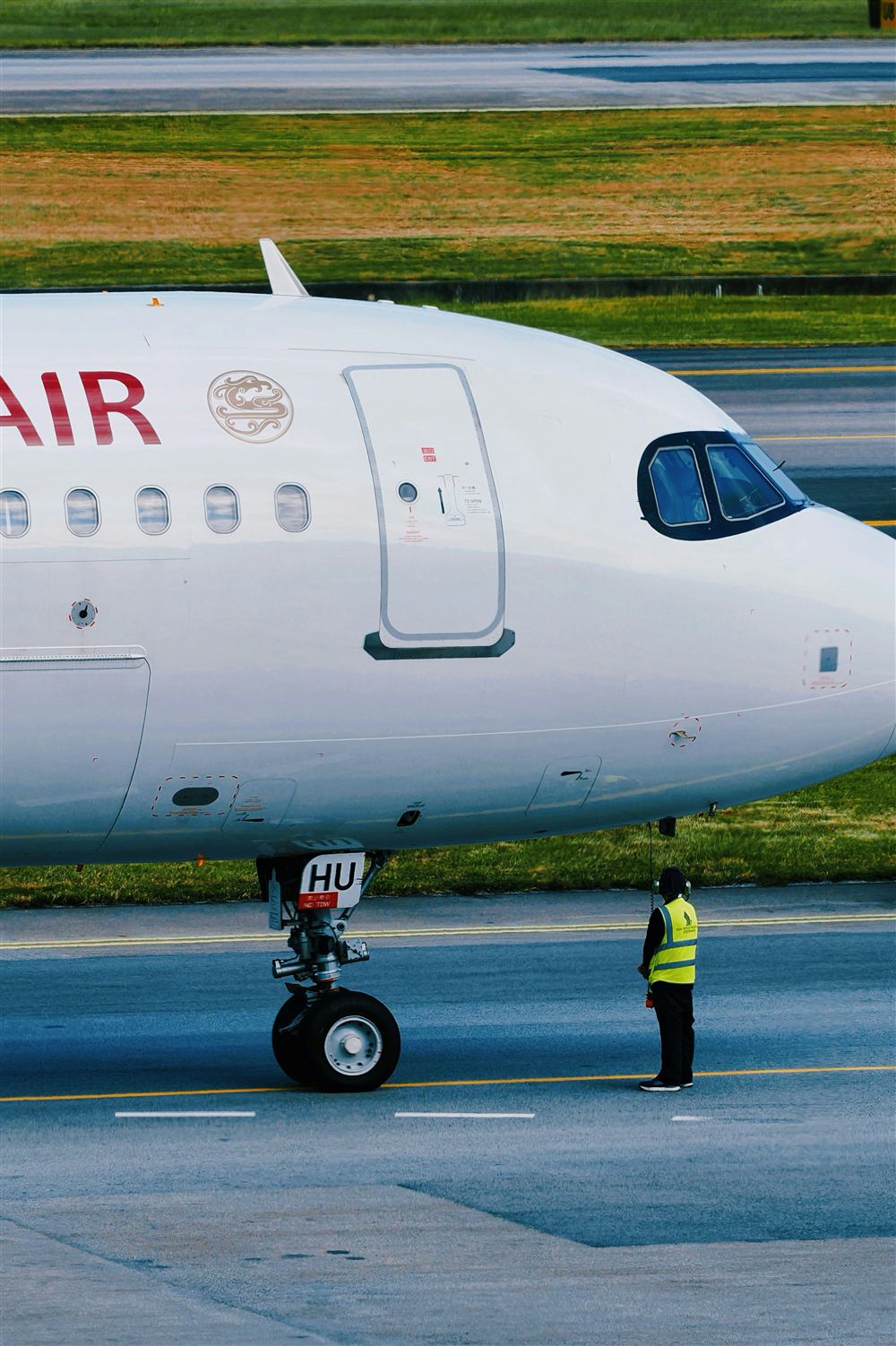 Ground crew member coordinating near an aircraft on the ramp.