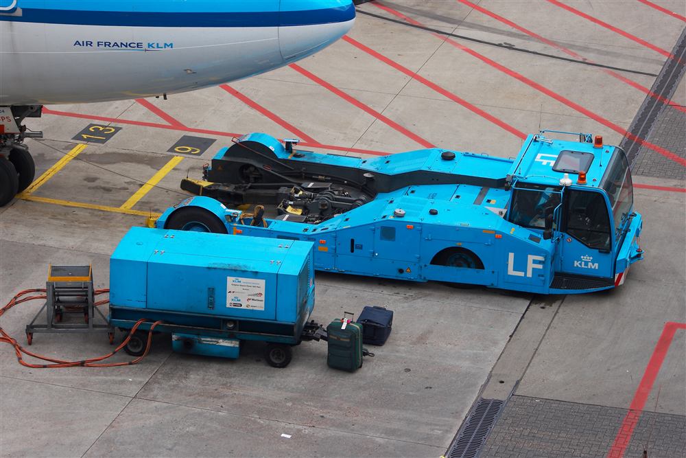 Ground power unit and pushback tractor positioned at an aircraft gate.